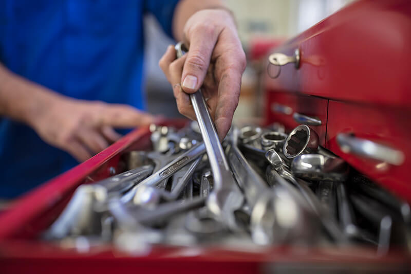 Hands of Male Car Mechanic Selecting Wrench from